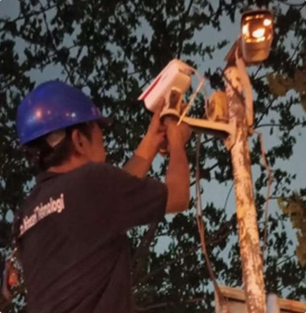 Teknisi menyesuaikan kamera pada tiang