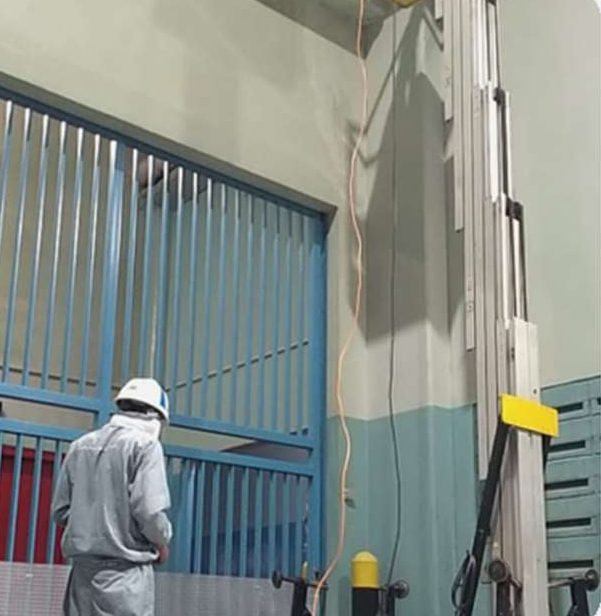 Teknisi bekerja dengan aerial lift di area industri